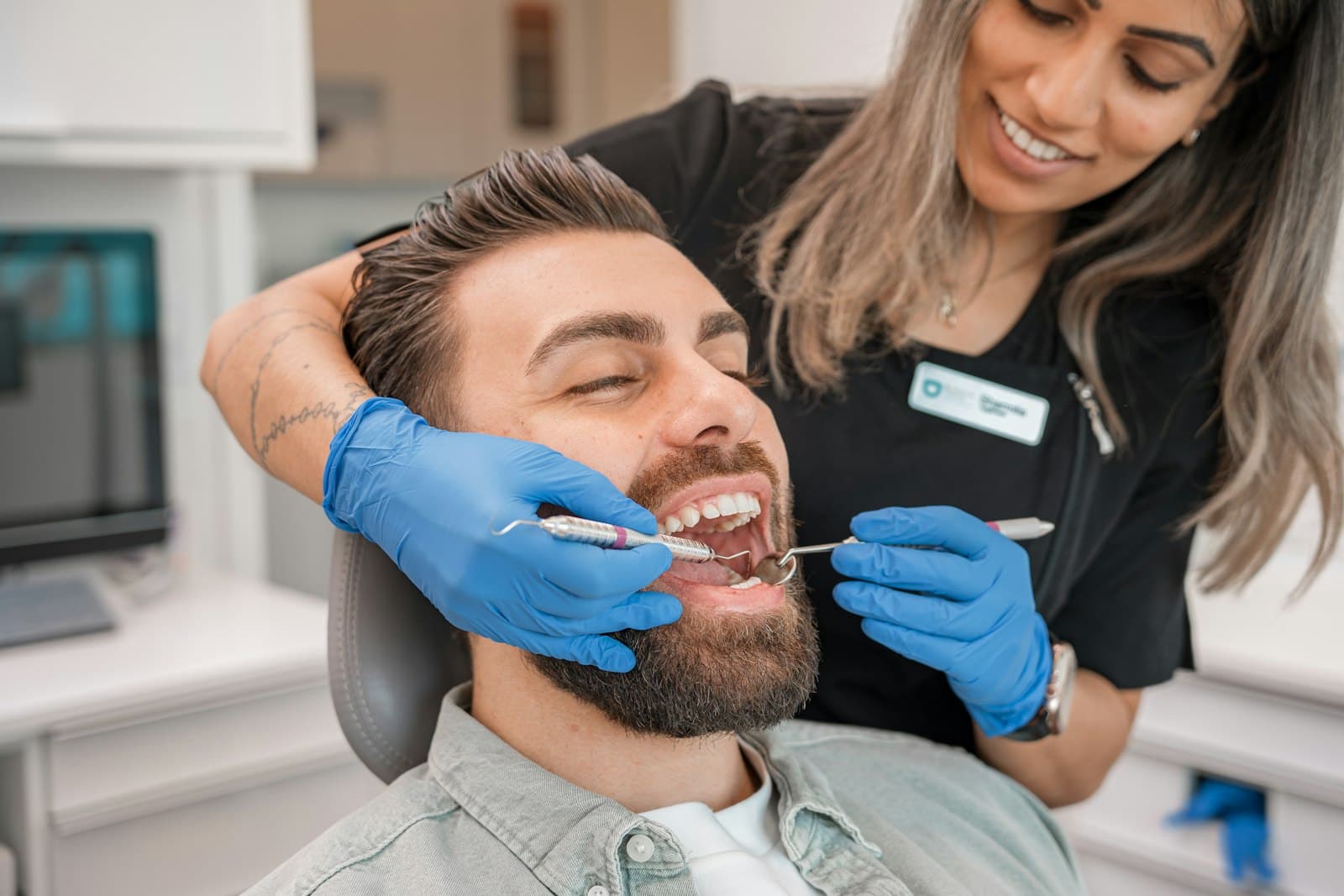 Smiling dentist examining a relaxed male patient in a modern dental clinic