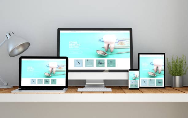 Responsive dental clinic website displayed on desktop monitor, laptop, tablet and mobile phone